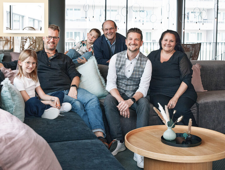 gastgeberfamilie-holzapfel-bad-füssing Die Gastgeberfamilie des Wellnesshotels Holzapfel sitzt zusammen lächelnd auf einer Couch