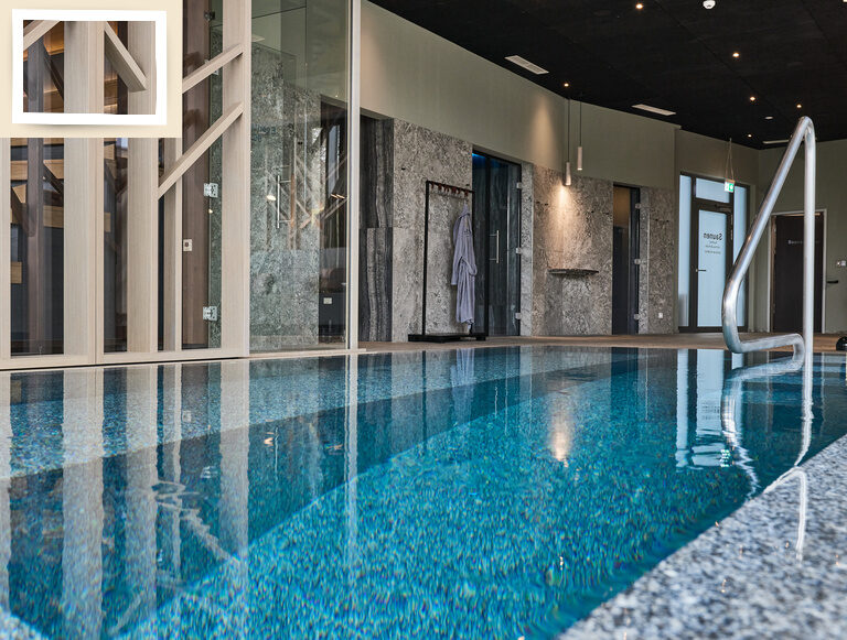 Ein stilvoller Swimmingpool im Inneren des Hotels Holzapfel